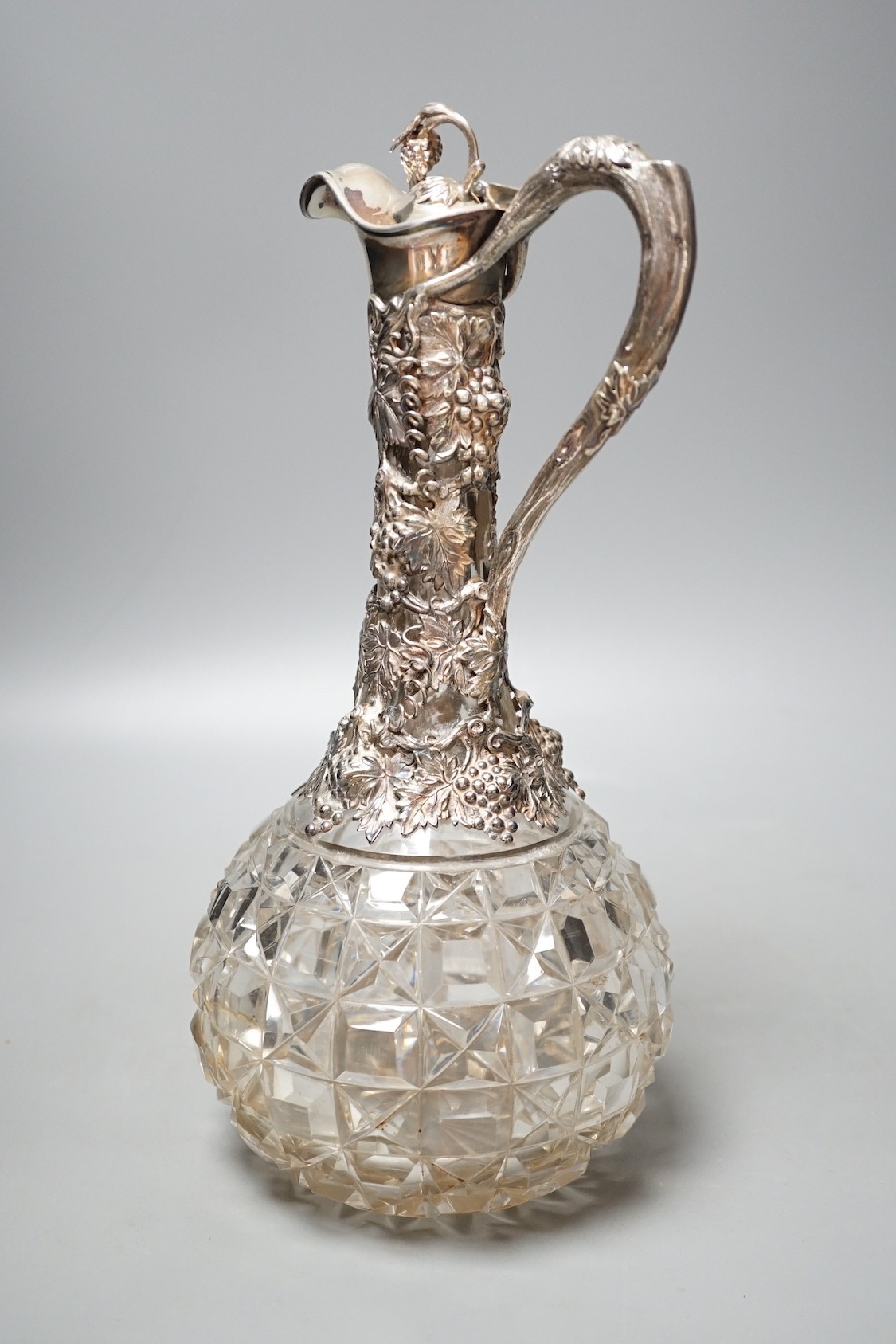 A Victorian silver mounted cut glass claret jug, with fruiting vine decoration, Cartwright & Woodward, Birmingham, 1860, 32cm.